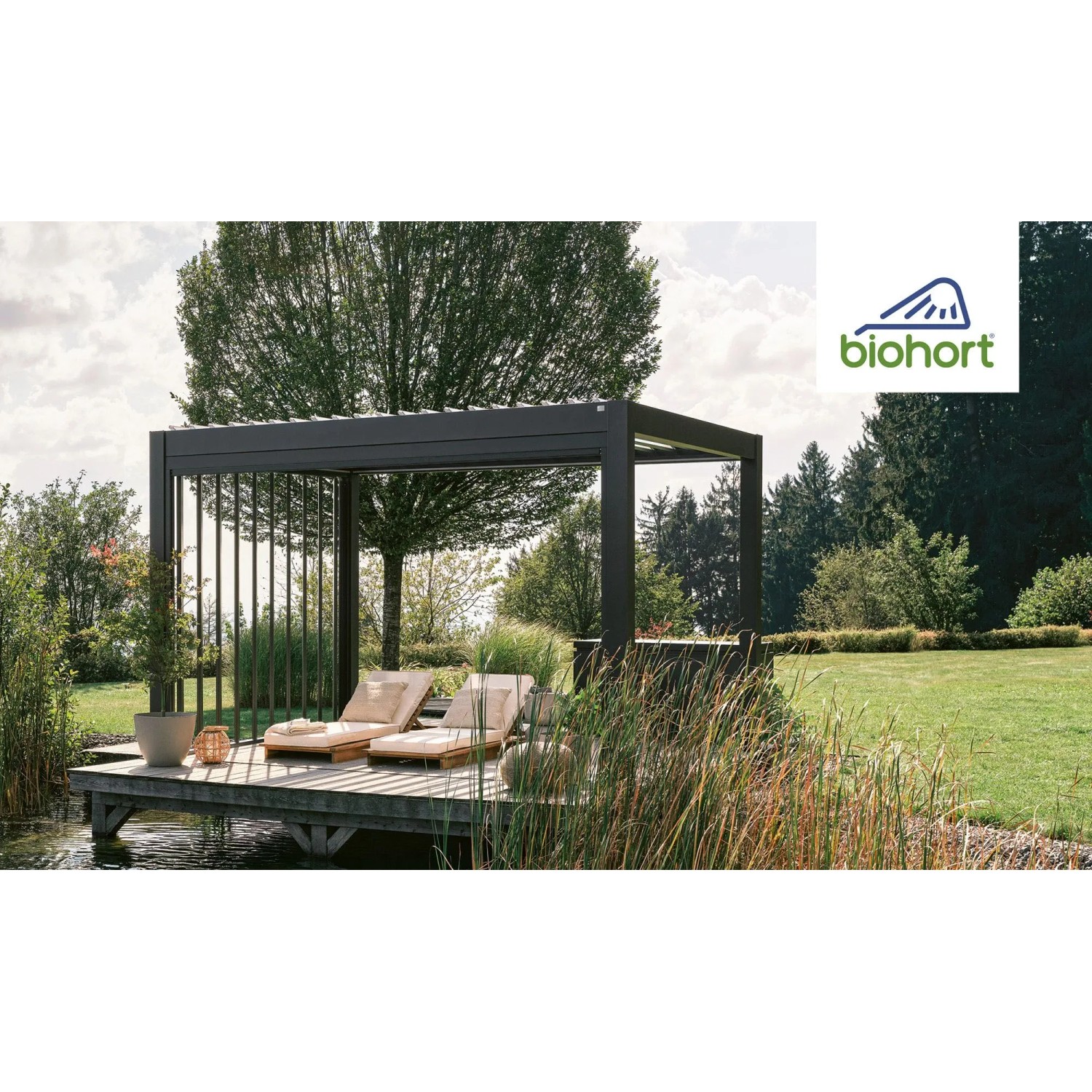 Moderne Biohort Pergola 5,5 m x 3 m in Quarz-Silber mit Lamellen und zwei Liegen auf einer Holzterrasse.