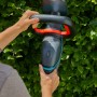 Gardena Akku-Heckenschere ComfortCut 50/18V in Nutzung vor grüner Hecke.