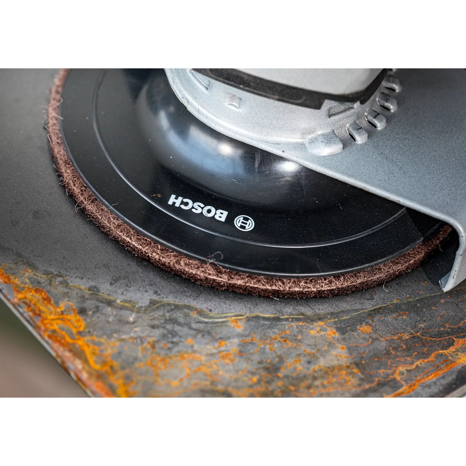 Bosch Expert Vliesscheibe N880, Ø 125mm, K120 auf Exzenterschleifer beim Schleifen von Metall.
