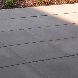 Verlegte graue Gehwegplatten 30x30 cm. Quadratische Terrassenplatten für Gartenwege und Terrassen.