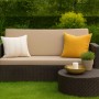 Beiges 2-Sitzer Gartensofa mit Kissen und Tisch aus Polyrattan. Gemütliche Lounge-Atmosphäre für Garten und Terrasse.