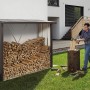 Biohort Kaminholzregal WoodStock 230, quarzgrau-metallic, mit Holzfüllung und Person beim Holzhacken.