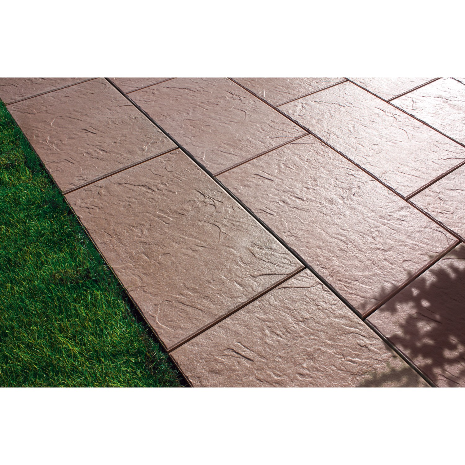 Verlegte, braun marmorierte Häusler Sandstein Steindielen (60x40 cm) auf einer Terrasse neben Rasen.