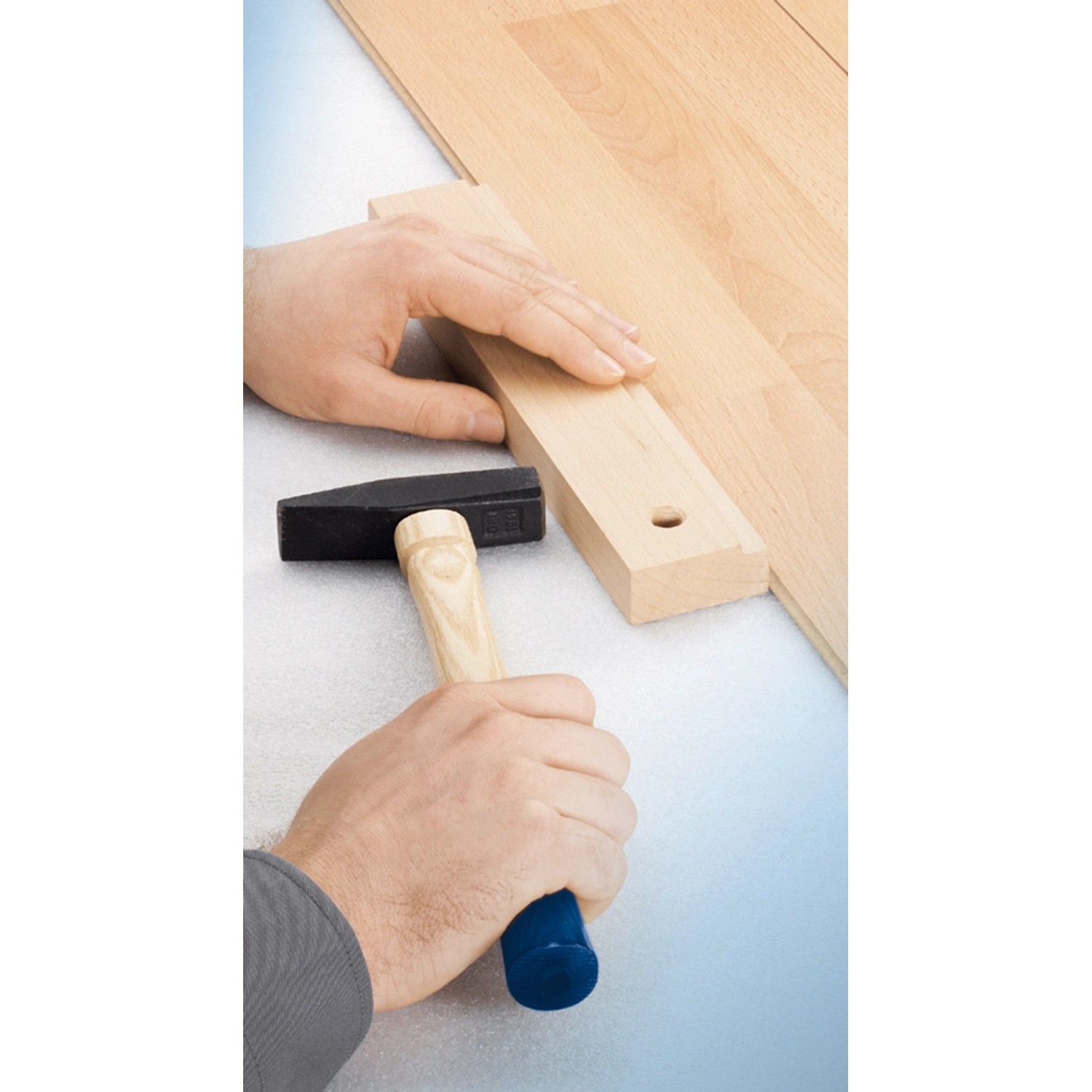 LUX Schlagleiste Klick Classic mit Hammer beim Laminat verlegen.