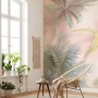 Wohnraum mit Komar Vliestapete Vague Botany in Pastellrosa mit Palmenmotiv.