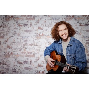 Mann mit Gitarre vor A.S. Creation Vliestapete Metropolitan Stories Paul Bergmann Berlin Mauerwerk.