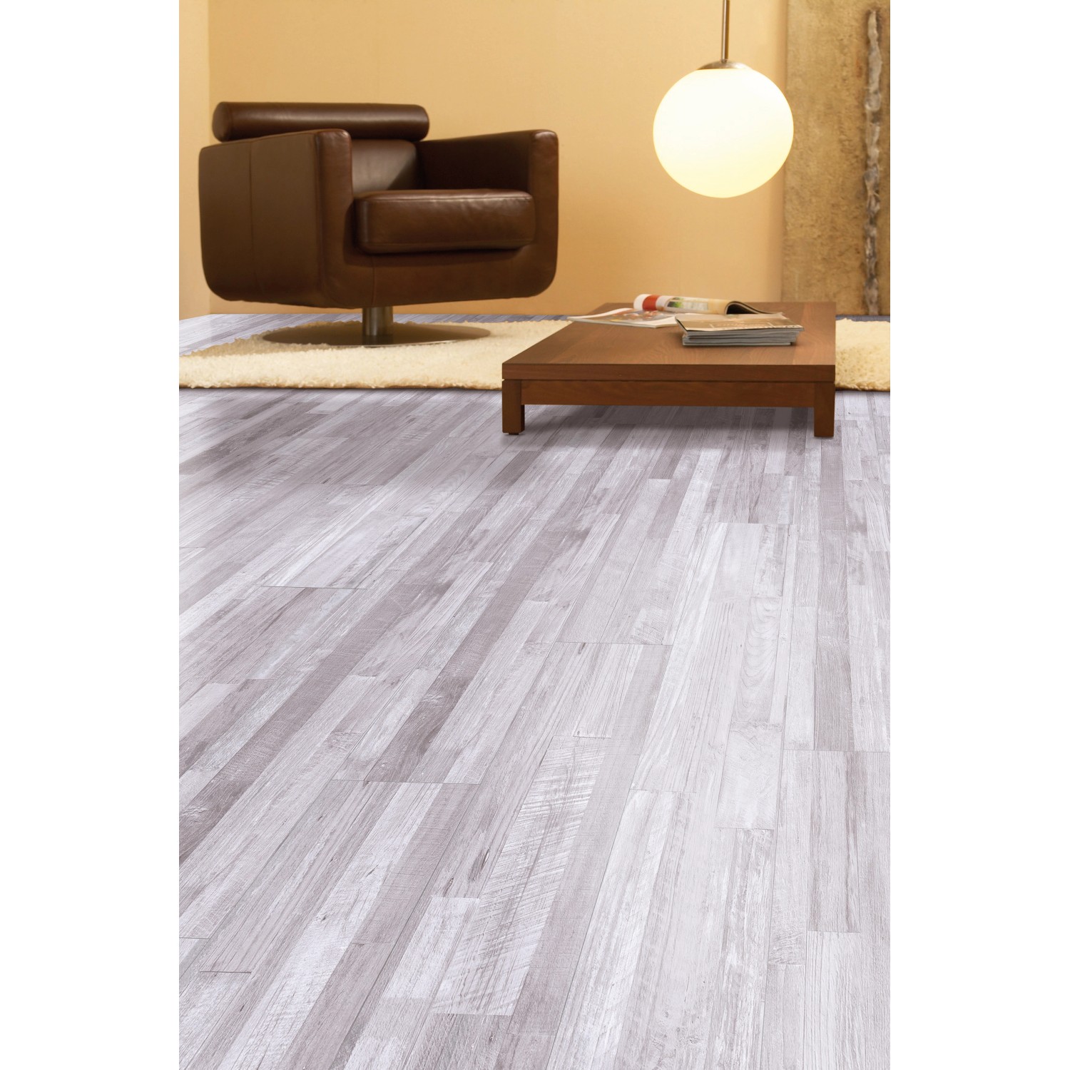 Heller Laminatboden im Pinie Sea Pine Dekor im Wohnraum mit Sessel und Tisch.