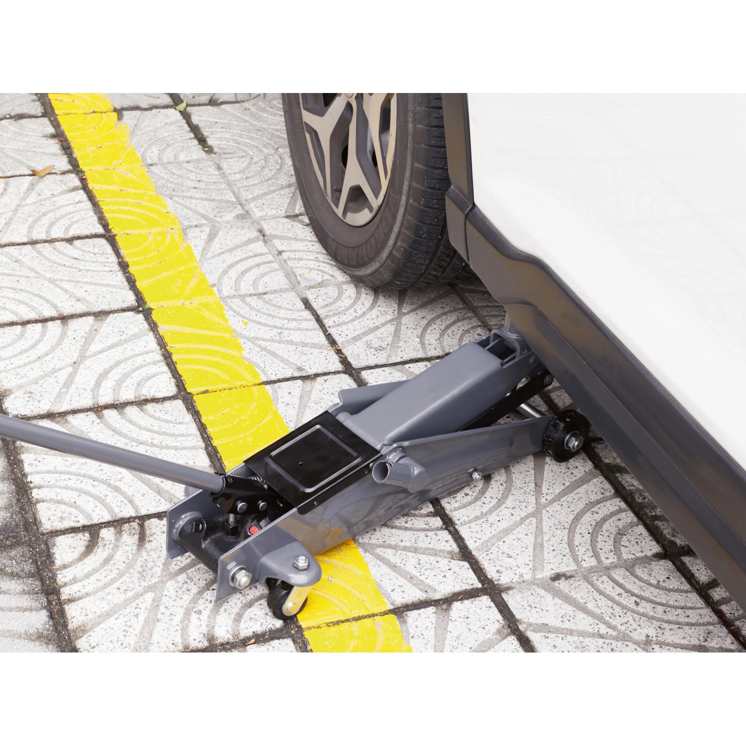 Grauer Rangierwagenheber RWH-2500 B 2,5 t unter einem Auto für Reparatur und Wartung.