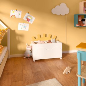 Kinderzimmer mit hafergelber Wandfarbe, Spielzeugkiste und Wolkenlampe.