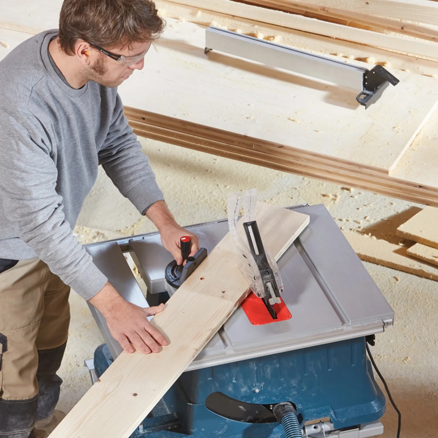 Mann sägt Holz mit Bosch Professional Tischkreissäge GTS 635-216. Kompakte Säge mit Zusatzsägeblatt.