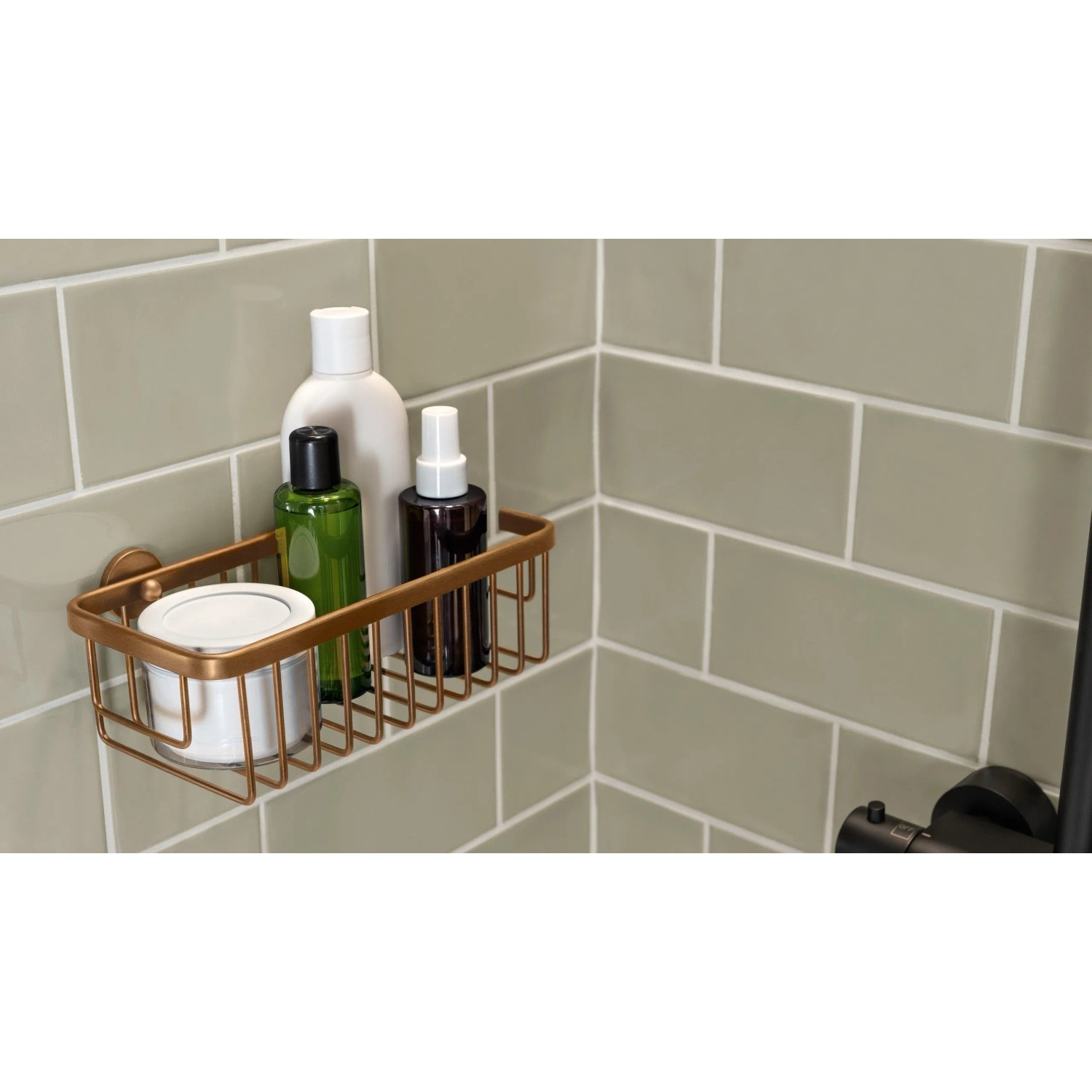 Tesa Moon Duschkorb in Bronze mit Shampoo und Duschgel an grauer Wand.