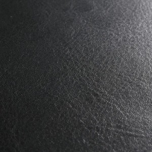 Detailaufnahme: Schwarzer MCW Sitzhocker Carrara, Bezug aus beschichtetem Spaltleder.