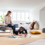 DEVI Fußbodenheizmatte DEVIcomfort 150T unter Holzboden. Familie genießt Wärme im Wohnzimmer. Heizungssystem.