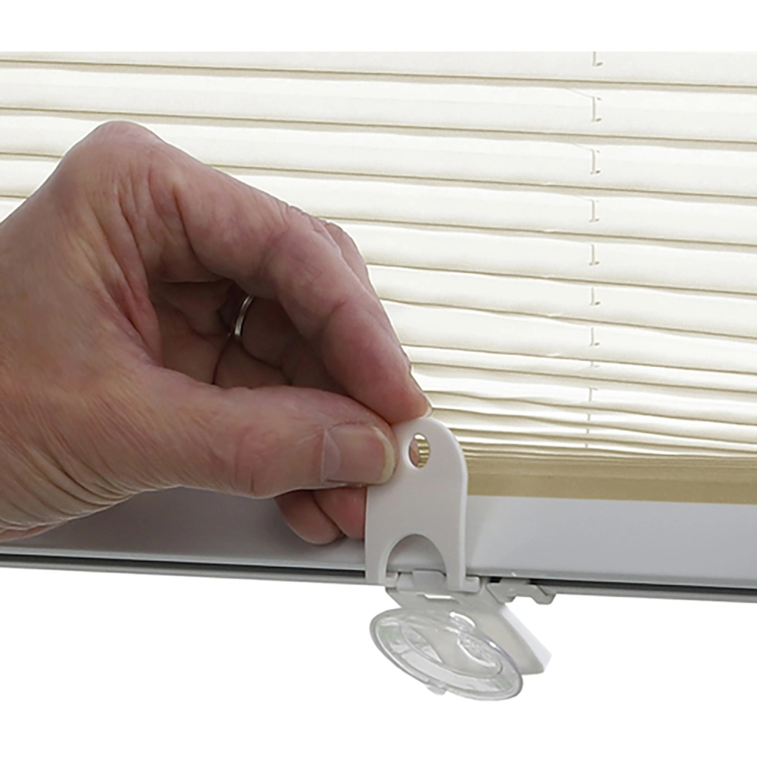 Detailaufnahme: Montage des creme-farbenen Gardinia Plissee Solo mit Saugnapf am Fenster.