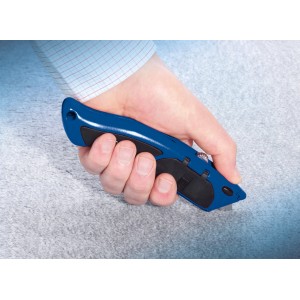 Hand schneidet Teppich mit blauem LUX Universalmesser Comfort 60 mm.
