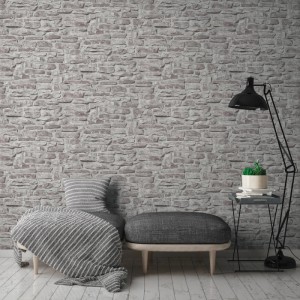 A.S. Création Vliestapete in Grau mit Naturstein Optik an einer Wohnzimmerwand.