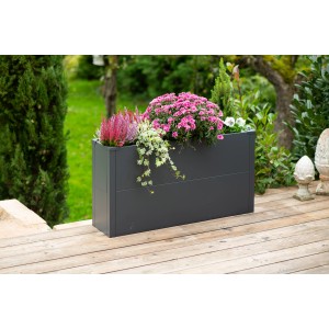 Anthrazitfarbener Westmann Pflanzkübel Talus L (25x100x52 cm) mit Bepflanzung auf einer Holzterrasse.
