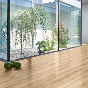 Parador Designboden Modular One SD Eiche Pure Hell im Raum mit Glaselement und Pflanzen.