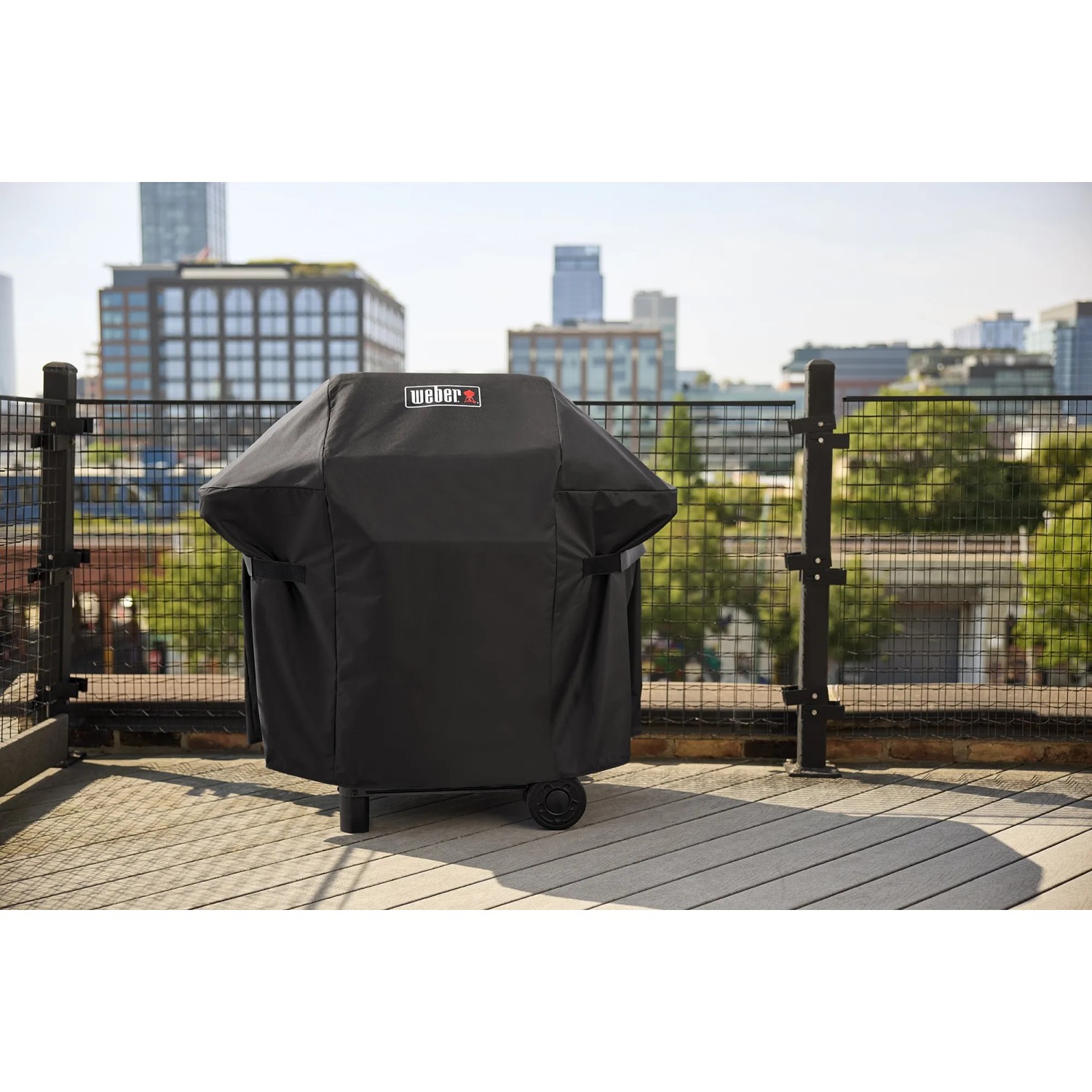 Abgedeckter, schwarzer Weber Gasgrill E-210 Spirit 2025 mit 2 Brennern auf einer Terrasse.