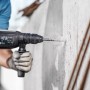 Bosch Hammerbohrer SDS Plus-3 beim Bohren in Betonwand, 24 mm Durchmesser.