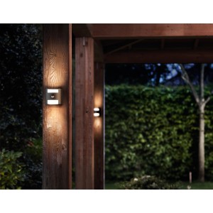 Philips LED-Außenwandleuchte Grass Anthrazit mit Bewegungsmelder an Holzpfosten.