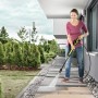 Frau reinigt Terrasse mit Kärcher Universalreiniger RM 555 und Hochdruckreiniger.