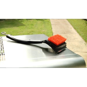 Char-Broil Grillbürste Cool Clean Premium mit Borsten und Schaber auf einem Grill.