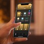 Smartphone mit der Philips Hue App zur Steuerung der Aurelle White Ambiance Leuchte.