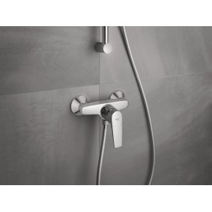 Grohe BauFlow Einhand-Brausebatterie in Chrom vor grauer Wand.