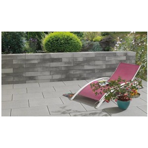 Anthrazit-schattierte Mauer aus Mauersteinen (45x22,5x12 cm) im Garten mit Liegestuhl.