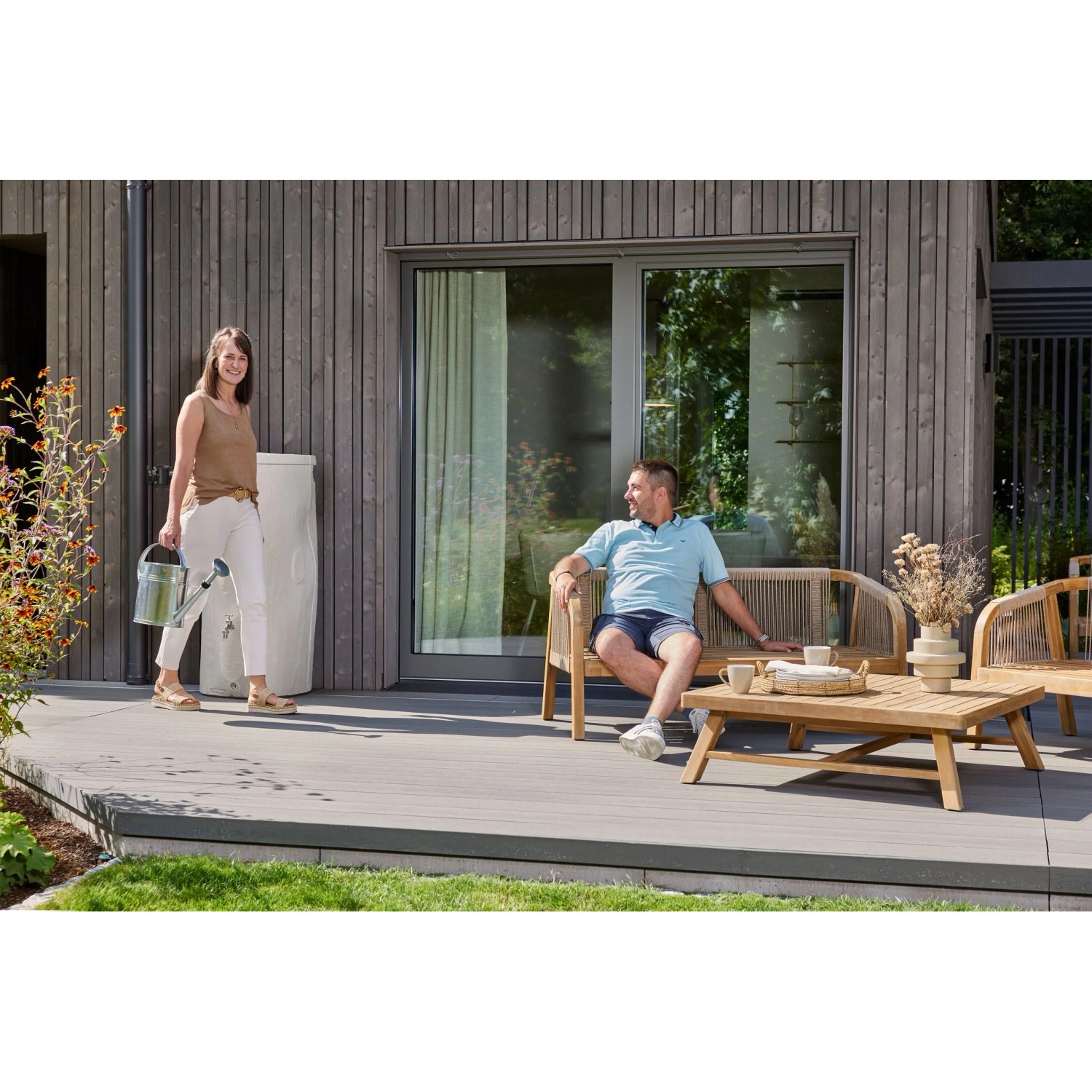 Garantia Regentonne Woodstock Baumstamm 250 l Greywood im Garten mit Personen.