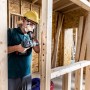 Handwerker bohrt mit Bosch Expert Flachfräsbohrer Löcher in Holzkonstruktion.