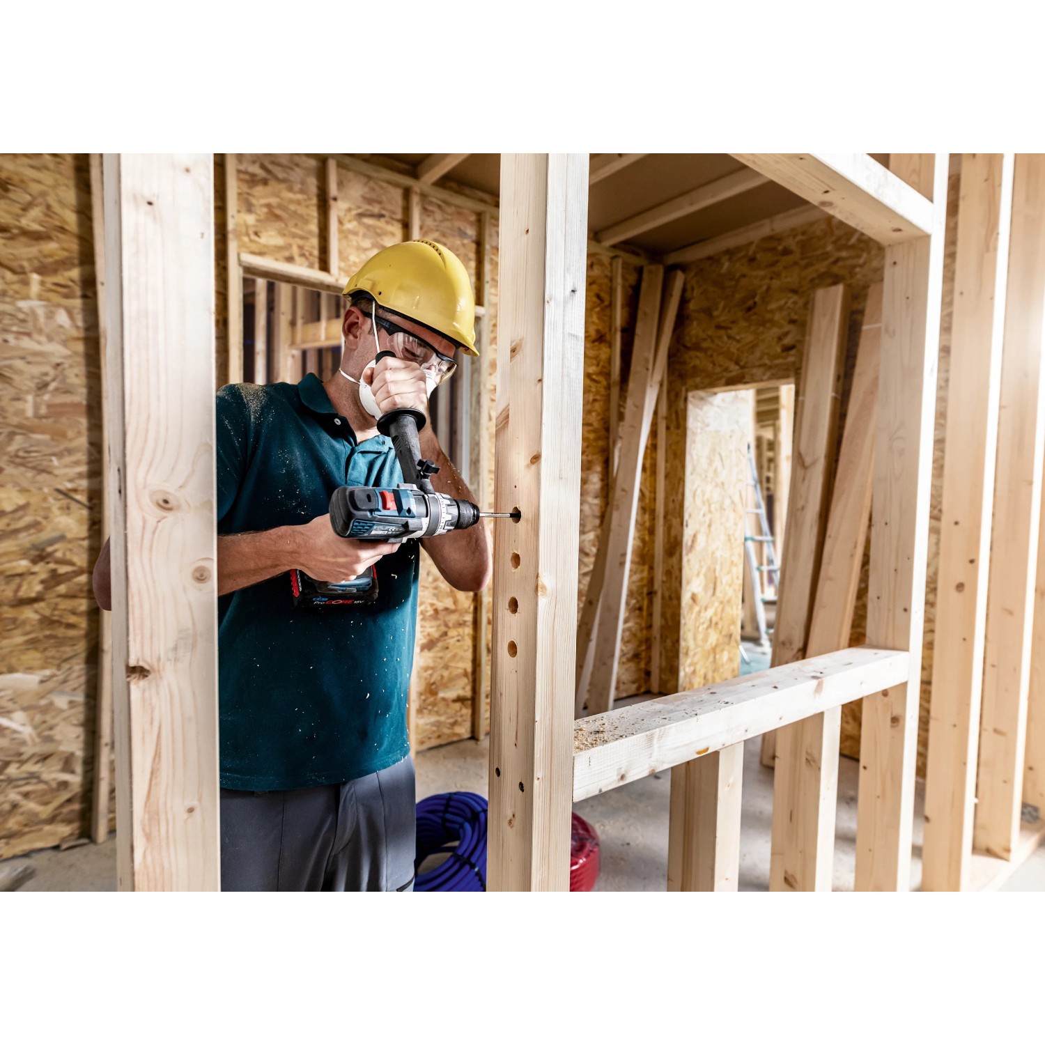 Handwerker bohrt mit Bosch Expert Flachfräsbohrer Löcher in Holzkonstruktion.