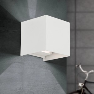 Weiße, quadratische LED Außen Wandleuchte aus Aluminium mit einstellbarem Abstrahlwinkel an grauer Hauswand.