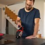 Mann benutzt Einhell Akku-Handstaubsauger TE-HV 18/06 Li-Solo auf einer Küchentheke.