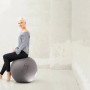 Frau sitzt auf grauem Sitting Ball Hocker Felt 150 l. Bequemer Sitzsack für Wohnzimmer.