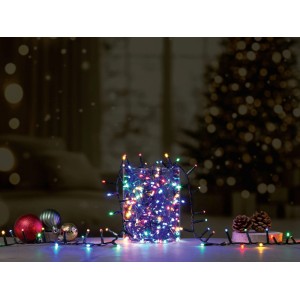 OBI LED Lichterkette 2000 LEDs, mehrfarbig leuchtend in Glas, umgeben von Weihnachtsdeko. Für festliche Außenbereiche.