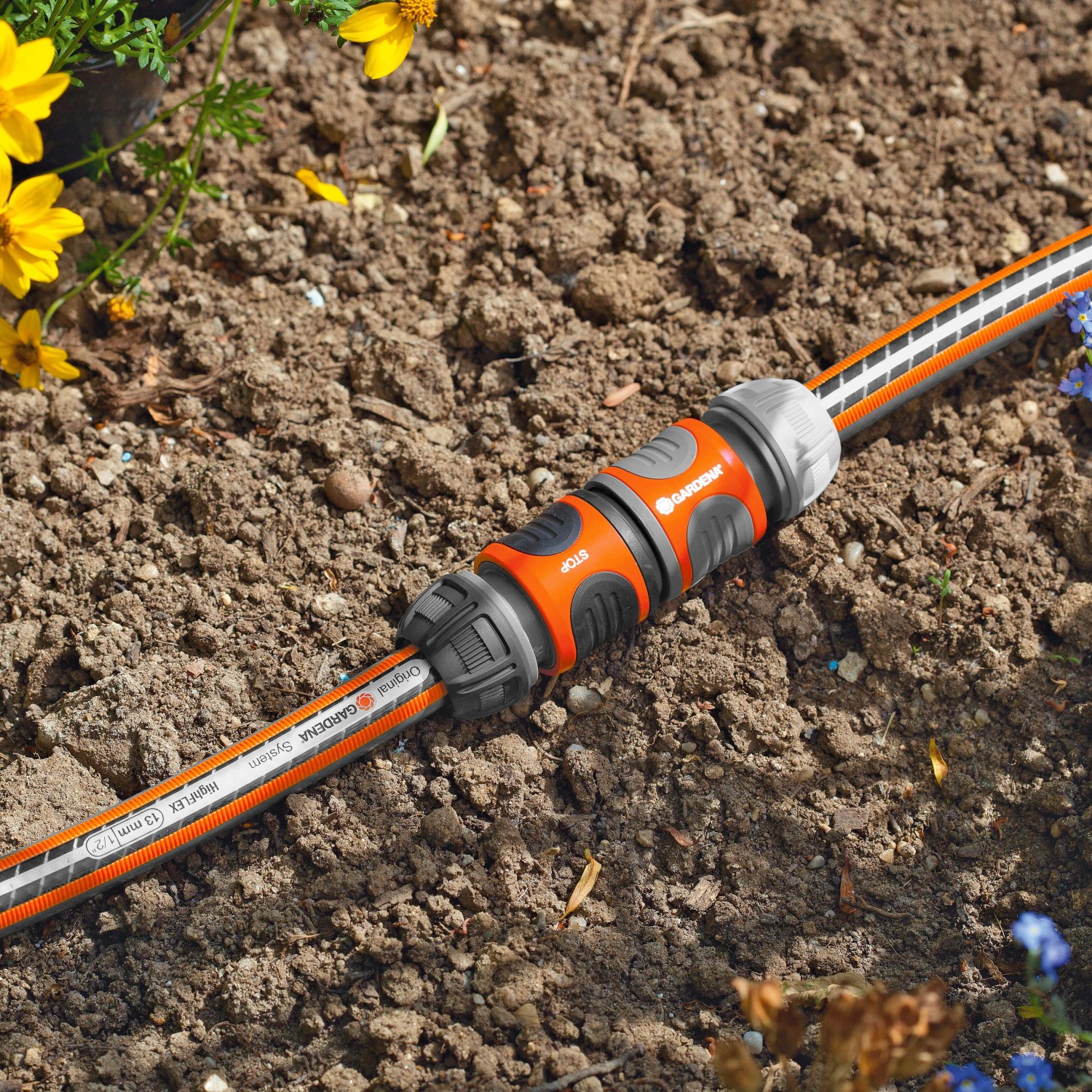 Gardena Kupplung zum Verbinden von zwei Gartenschläuchen im Beet.