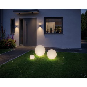 Drei leuchtende Paulmann Globe LED-Leuchten im Garten vor einem Haus. Warmweißes Licht.