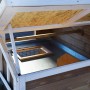 Detailansicht Hühnerstall XL: Blick ins Innere mit Zinkwanne und Öffnung zum Freigehege.