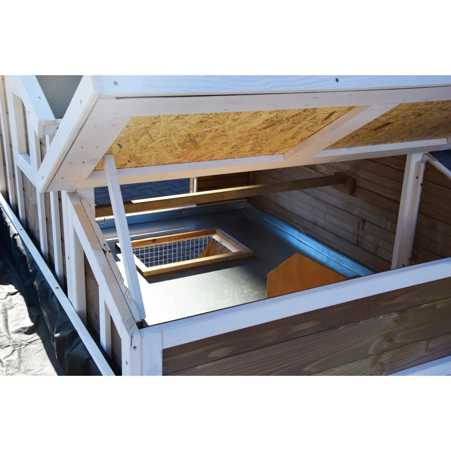 Detailansicht Hühnerstall XL: Blick ins Innere mit Zinkwanne und Öffnung zum Freigehege.