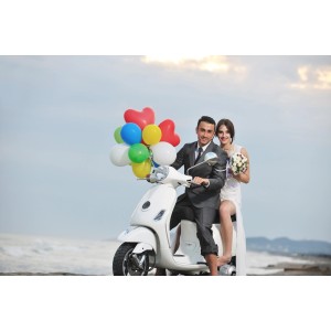 Paar auf Roller mit bunten Ballons. Rothenberger Ballon-Party-Set für Hochzeit oder Geburtstag.