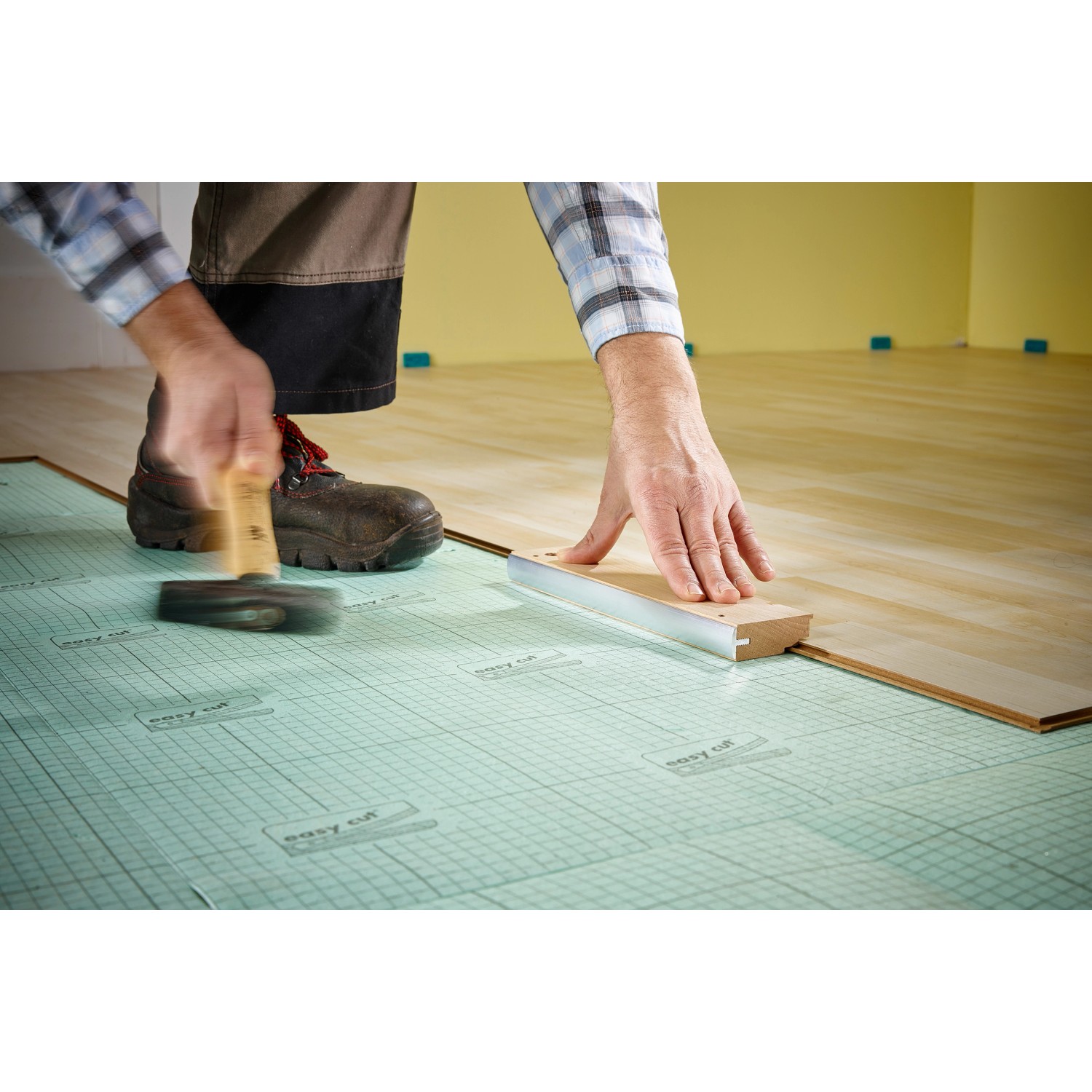 Anwendung des wolfcraft Schlagholz Profi zum Verlegen von Laminat oder Parkett.