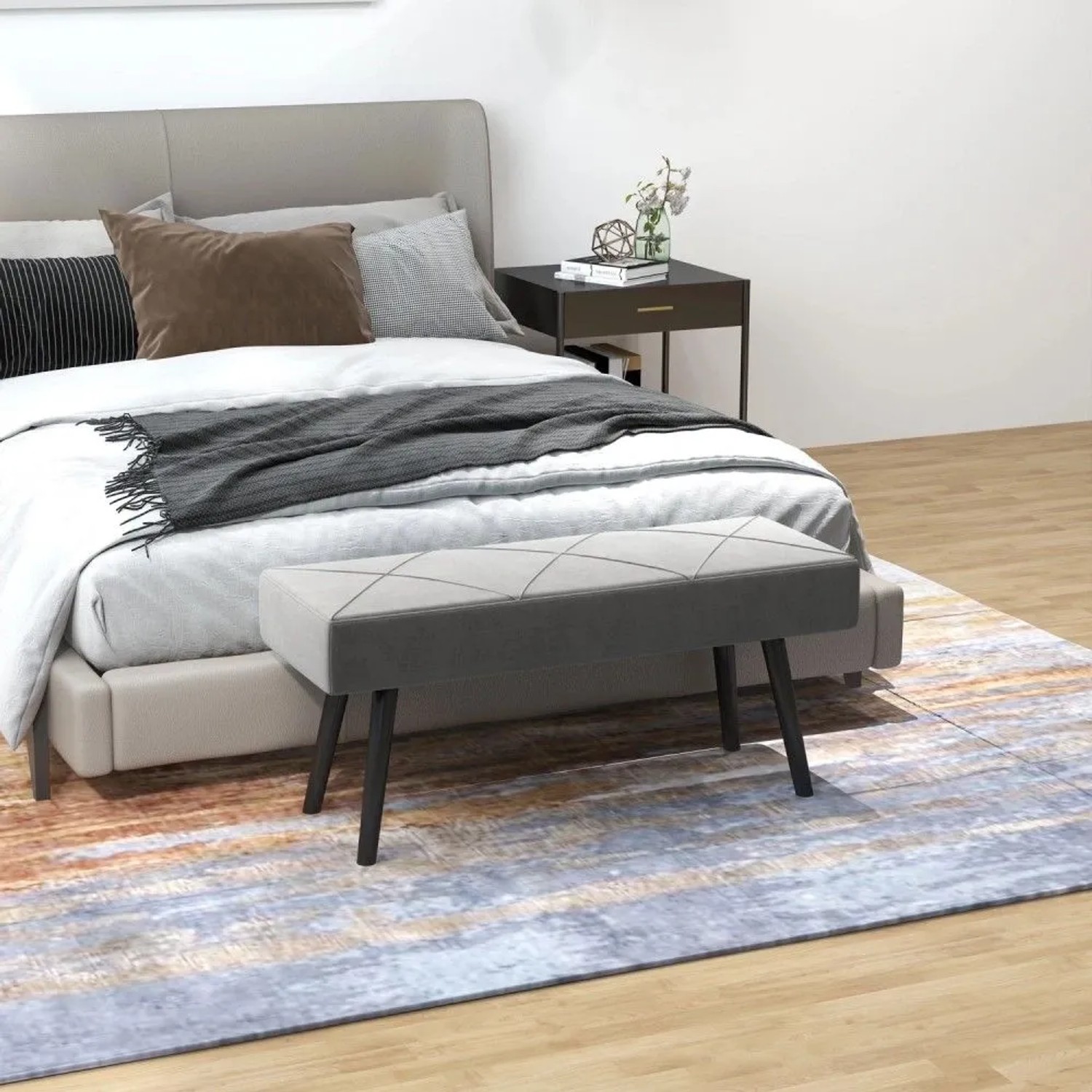 Graue Polsterbank mit X-Muster in Samtoptik und schwarzen Stahlbeinen, ideal als Sitzbank im Schlafzimmer.