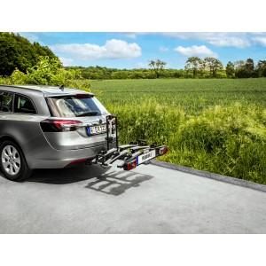 Eufab Premium 3 Fahrradträger auf Anhängerkupplung montiert an silbernem Auto vor grüner Landschaft.
