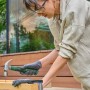 Frau arbeitet mit Hammer aus Bosch Werkzeugkoffer Advanced Set an Holzkonstruktion.