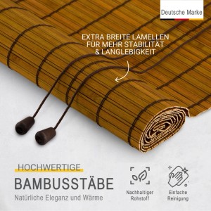 Braunes Bambusrollo Sol Royal mit breiten Lamellen und Zugschnüren, teilweise aufgerollt, für Fenster und Sichtschutz.