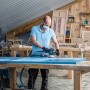 Handwerker schleift blaue Holzplatte mit Bosch Exzenterschleifer und Schleifblatt C470.