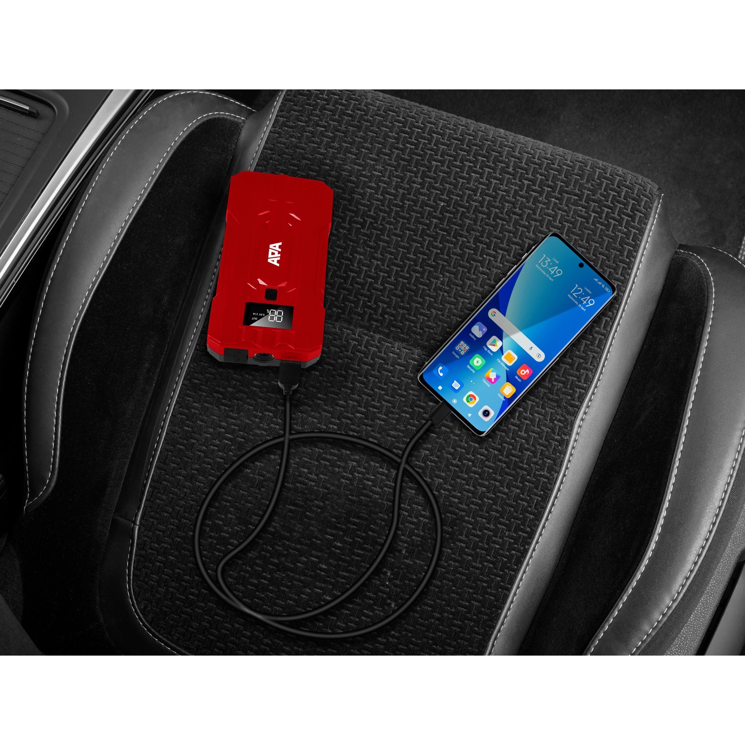 Rotes Apa Schnellstartsystem Powerpack 10.000 mAh lädt Smartphone im Auto.