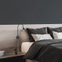 Schwarze Briloner LED Bettleuchte Tusa mit Flexarm am Bett montiert.